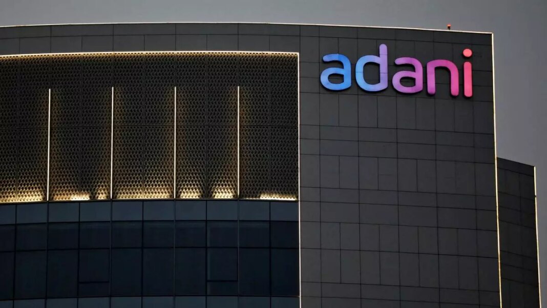 Adani logo on modern building facade at dusk