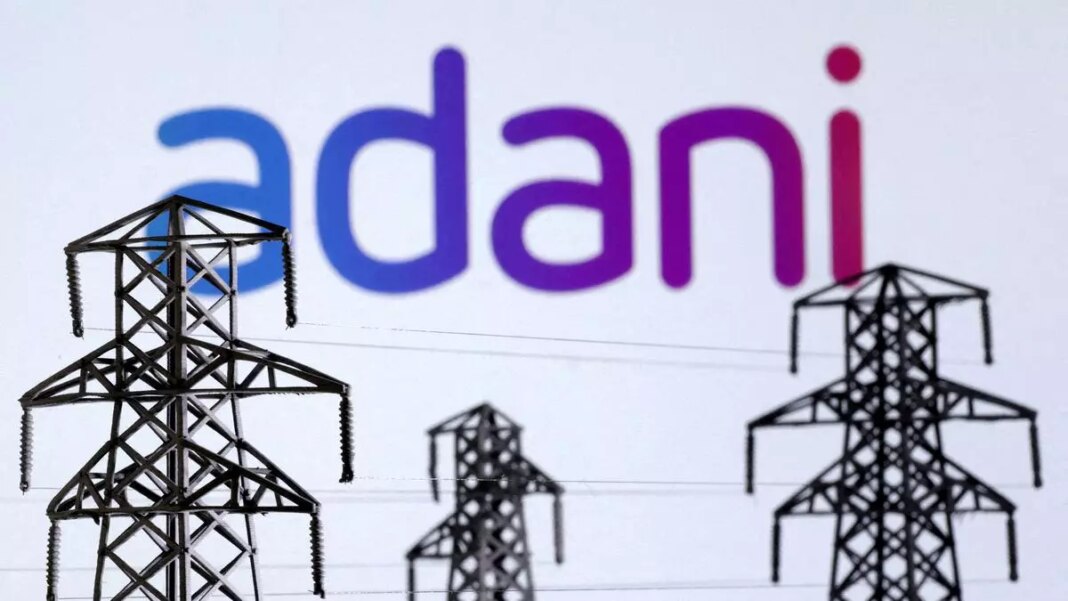 Adani logo with electric pylons in foreground.