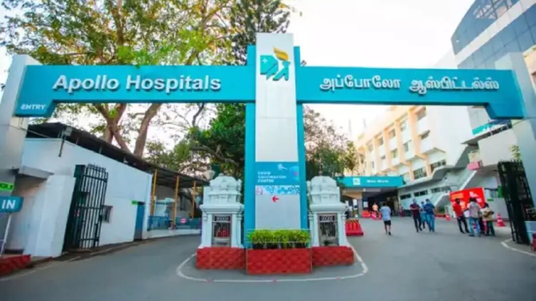 Entrance of Apollo Hospitals with people and signage.