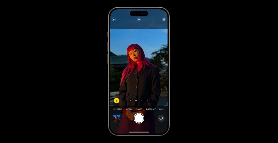 Woman with pink hair on phone camera screen.