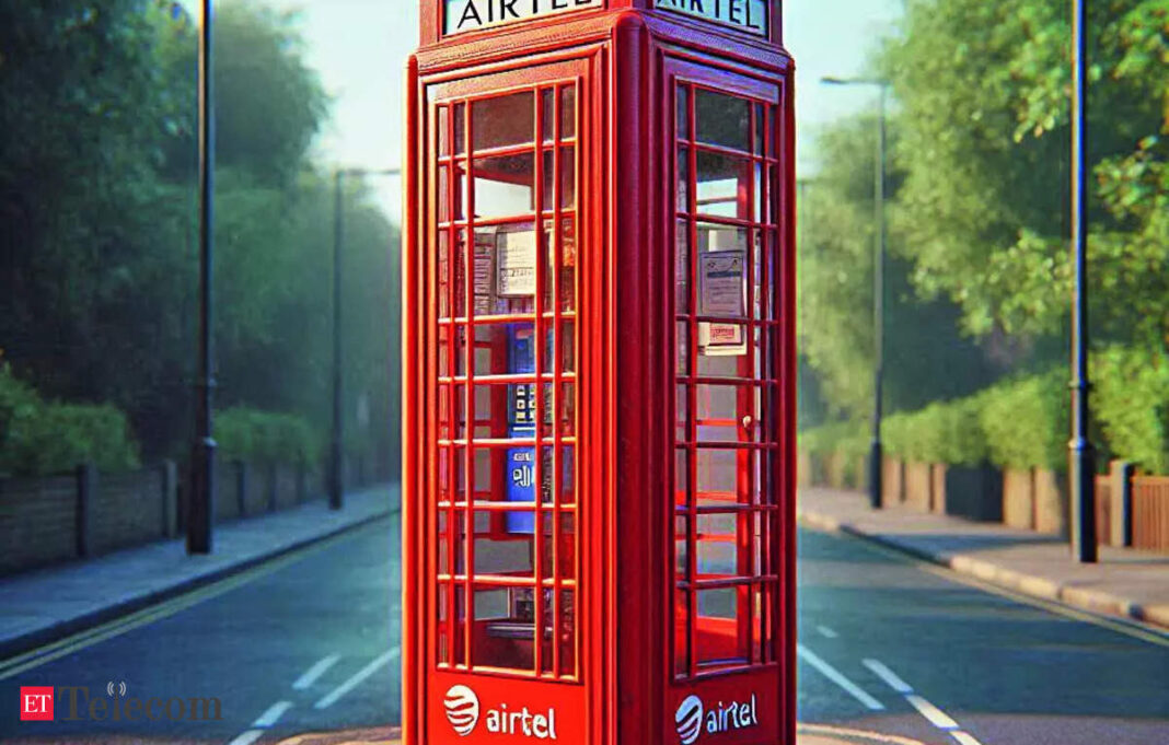 Red phone booth on a sunny street.