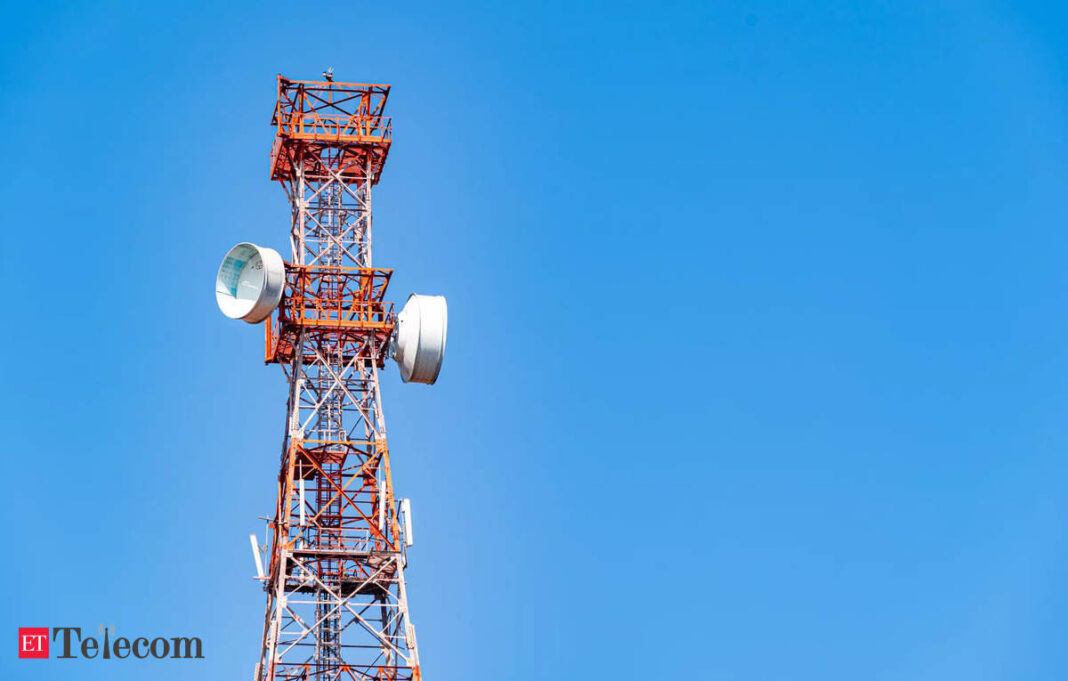 Cellular tower against clear blue sky.