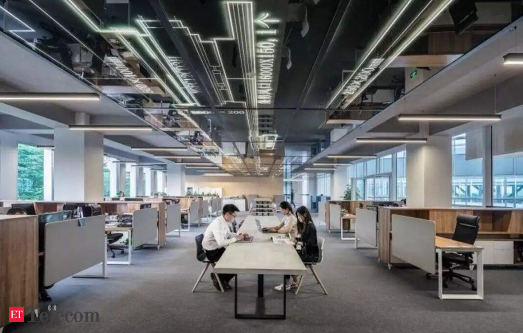 Modern office space with employees working at desks.