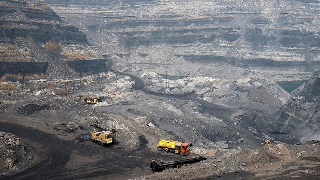 Open-pit mine with trucks and excavator.