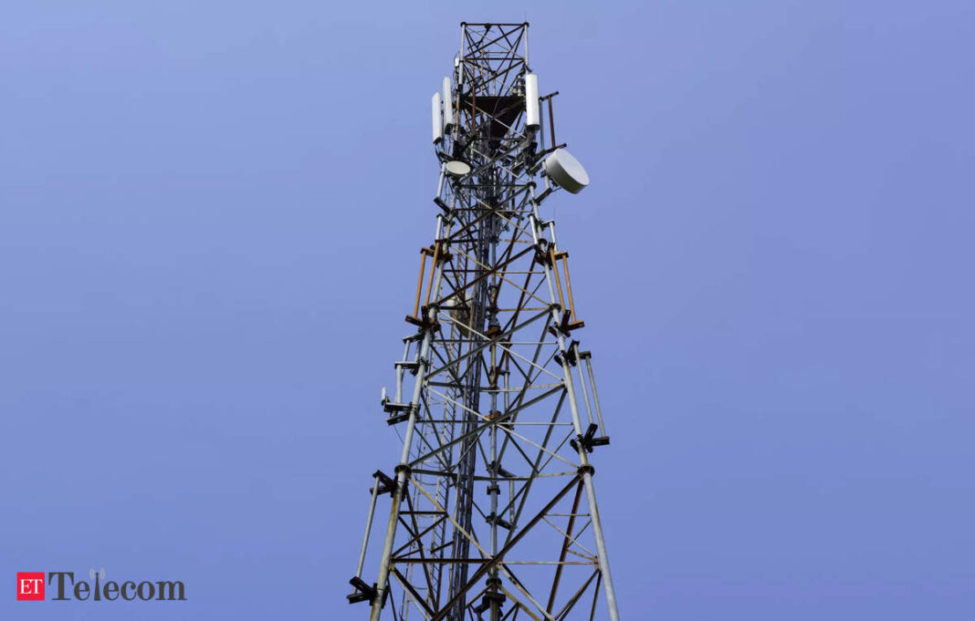 Cellular tower with antennas against blue sky.