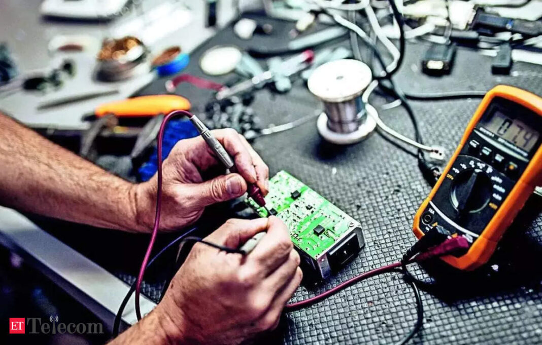 Technician soldering components on electronic circuit board.