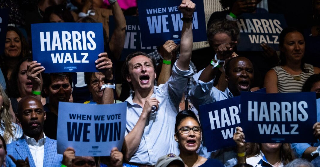 Crowd holding political campaign signs.