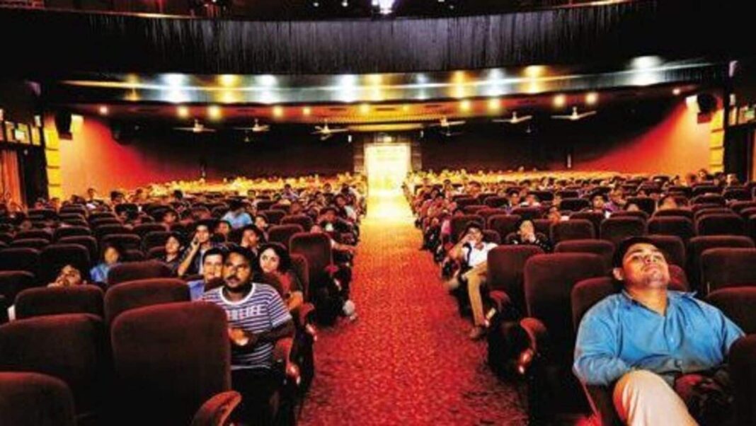 Audience watching movie in cinema theater.