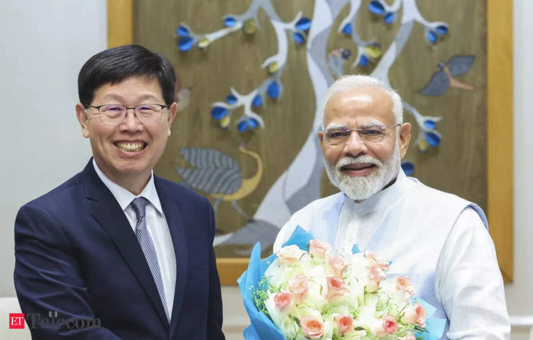 Two men smiling, one holding a bouquet of flowers.