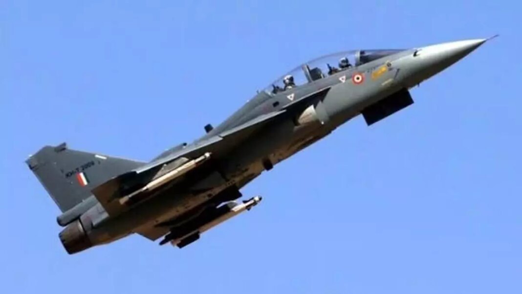 Military jet flying against blue sky.