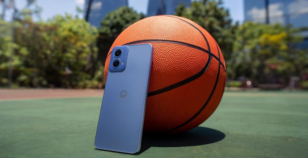 Smartphone leaning against basketball on court.