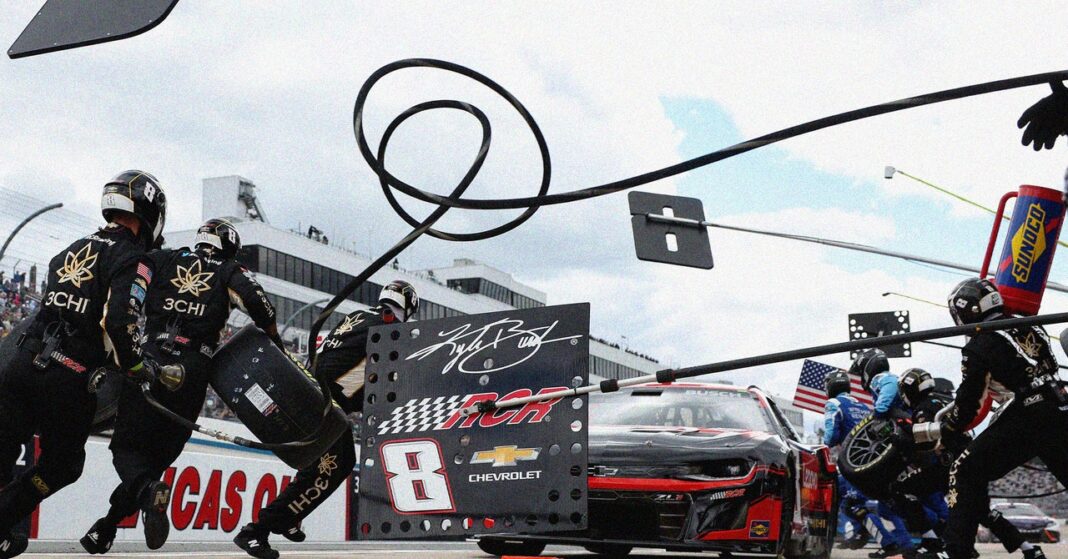 Pit crew servicing NASCAR race car during a race.