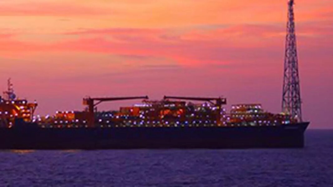 Cargo ship at sunset with illuminated lights