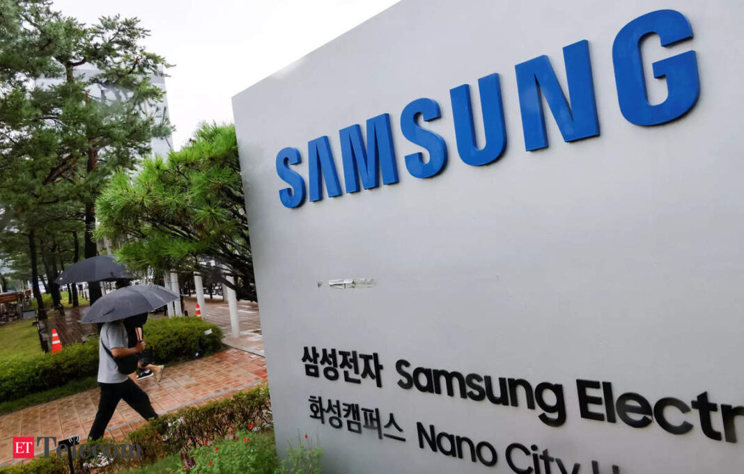 Person walks by Samsung sign in rainy weather.