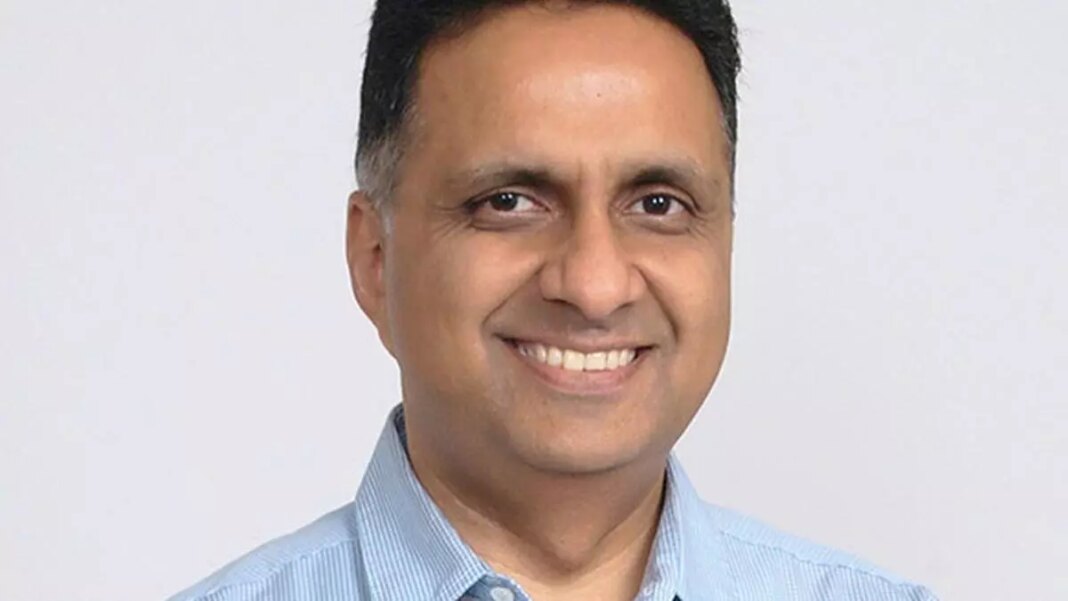 Smiling man in blue shirt against white background.