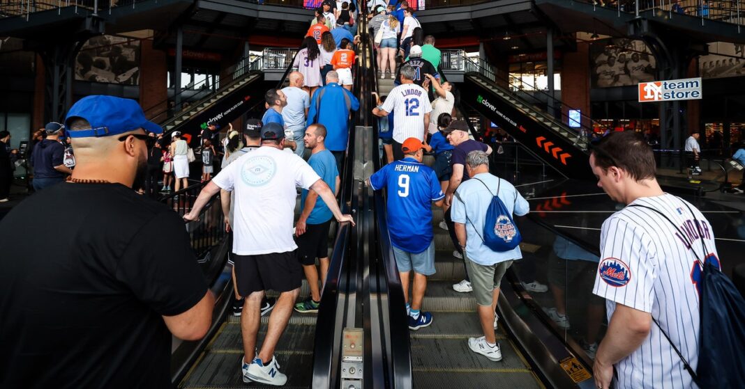 Crowd ascending escalator at sports venue