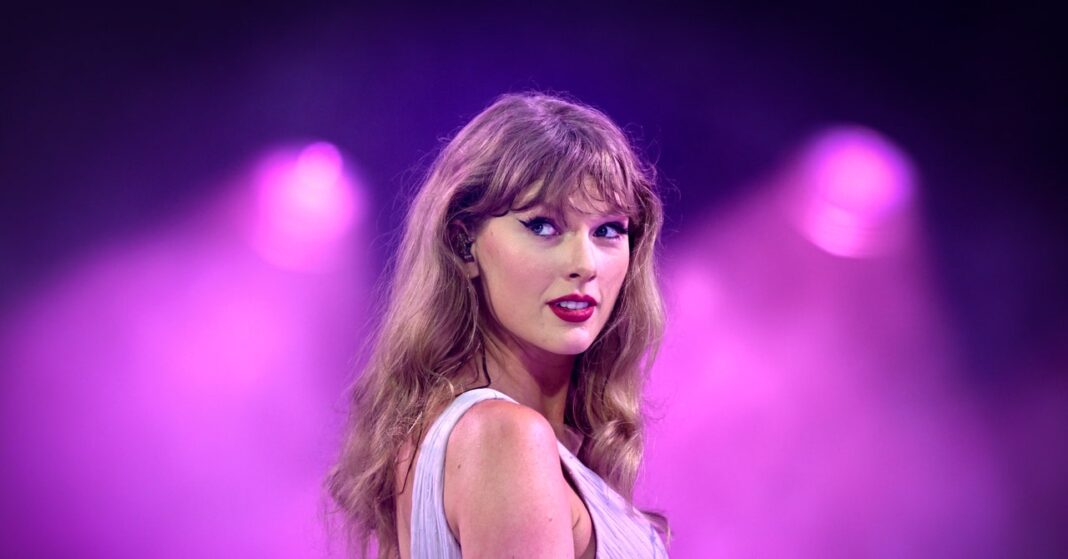 Woman performing onstage with purple lighting effects.