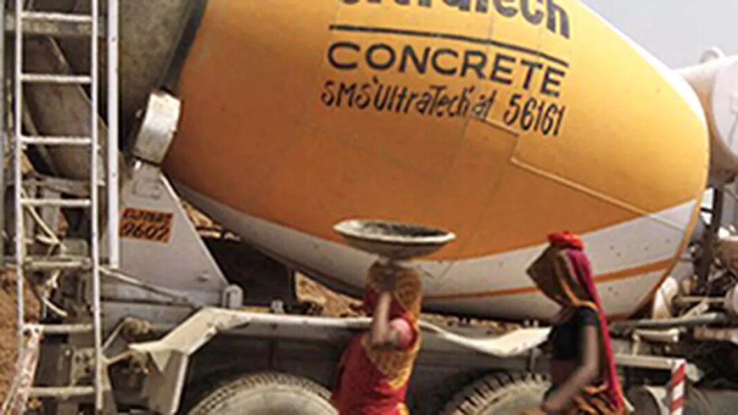 Two workers beside yellow concrete mixer truck.