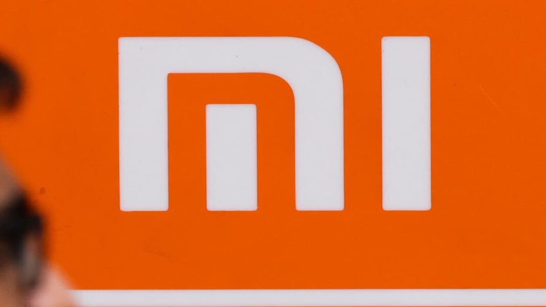 Xiaomi logo close-up with orange background.