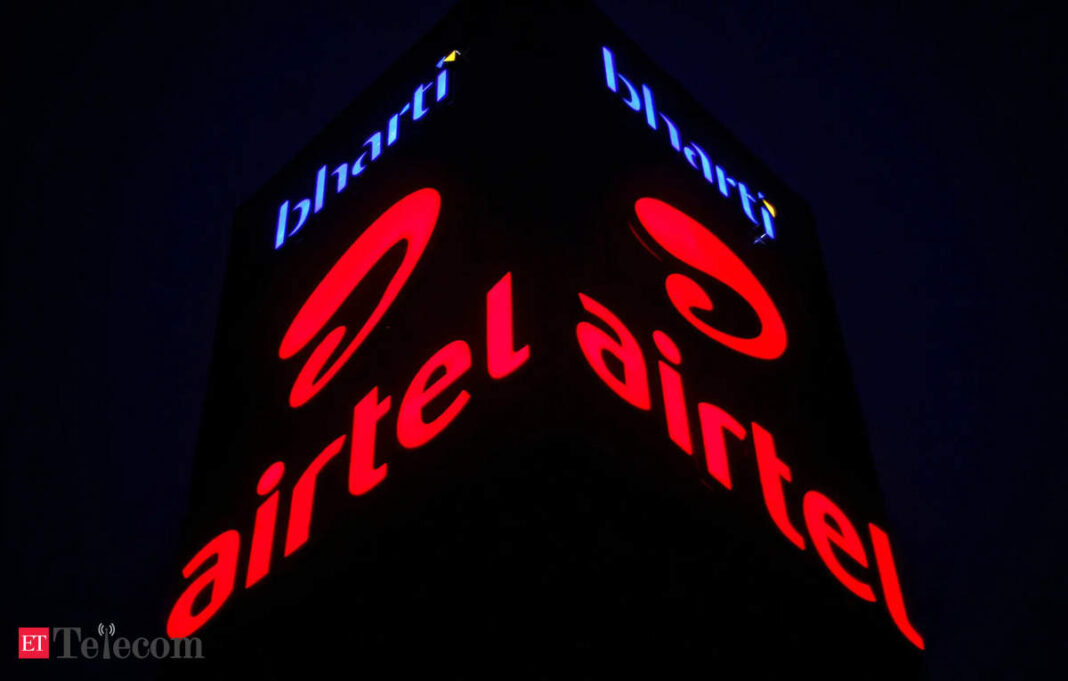 Illuminated Airtel logo on building at night.