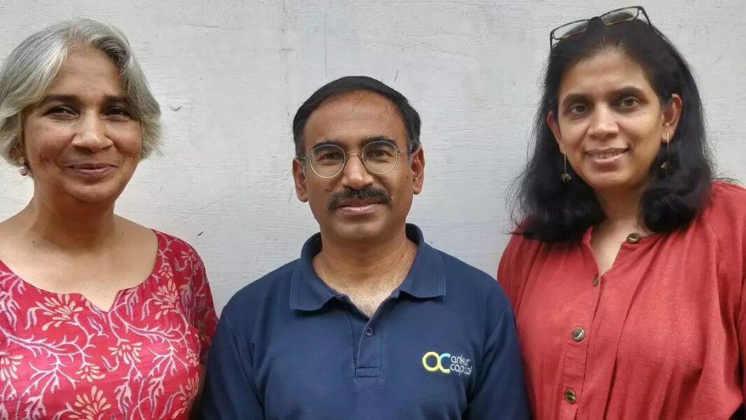 Three adults smiling outdoors.