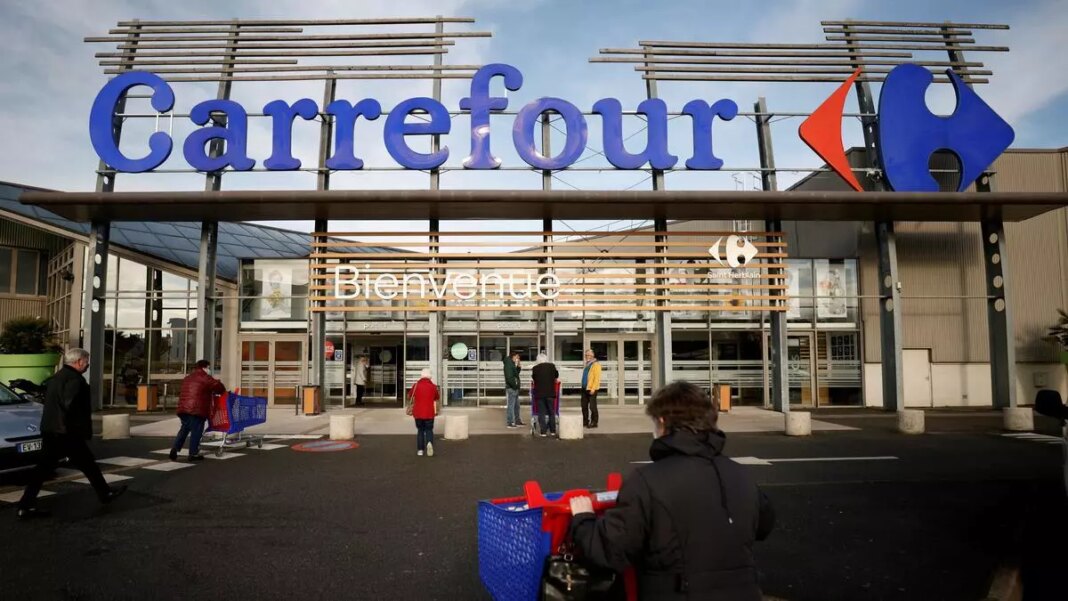 Carrefour supermarket entrance with shoppers and carts.