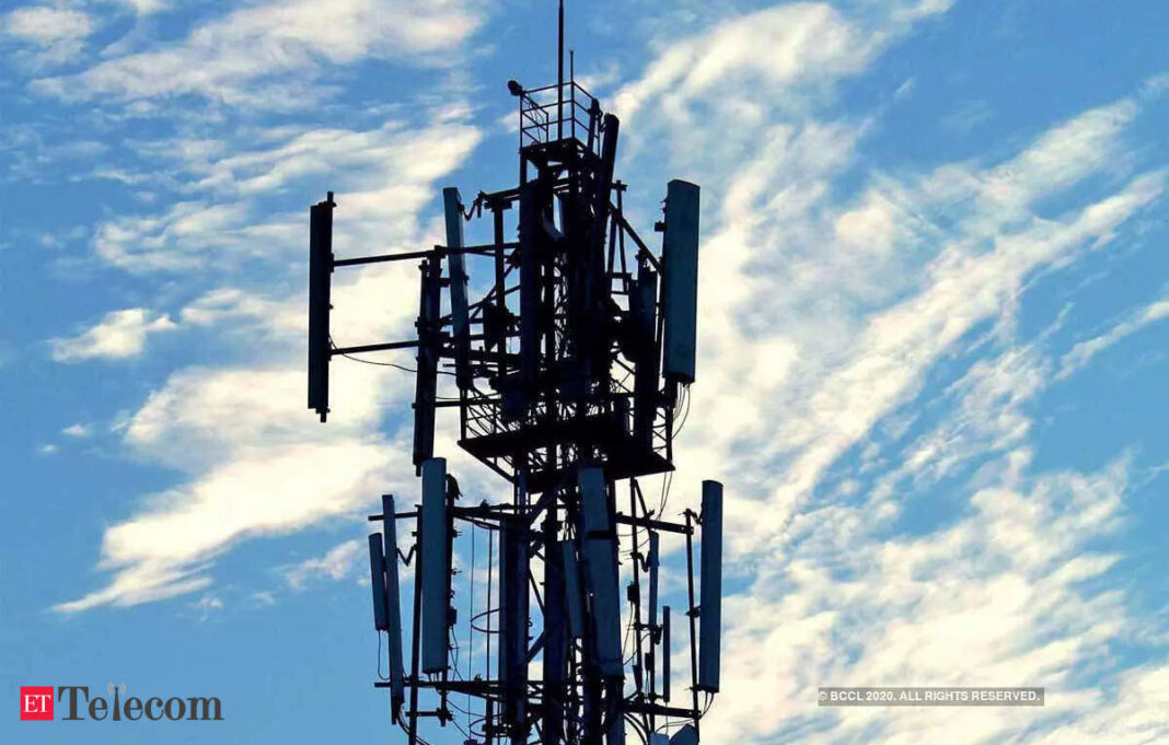 Cellular tower silhouette against blue sky.