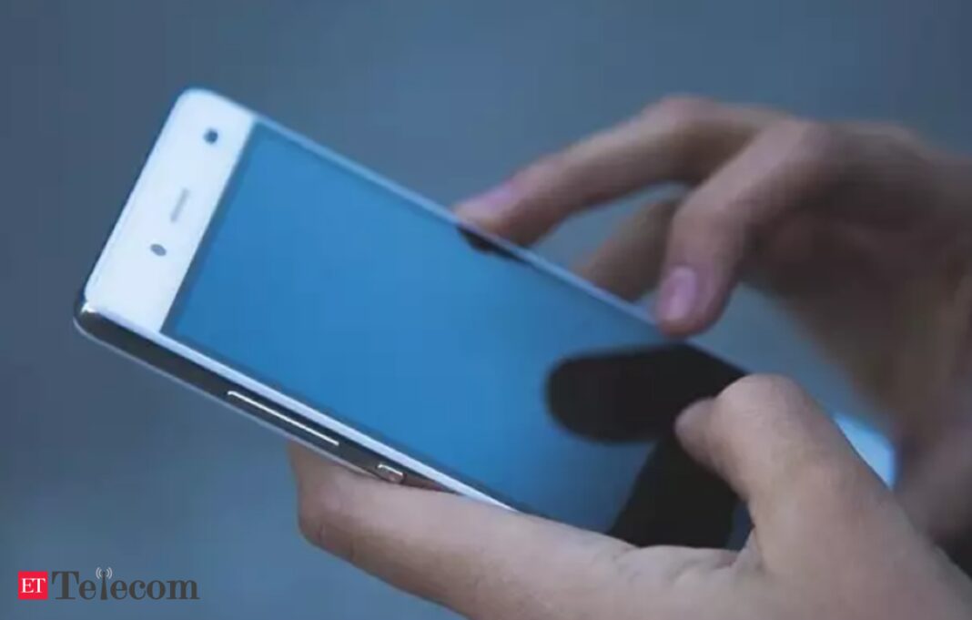 Person holding smartphone with blue screen.