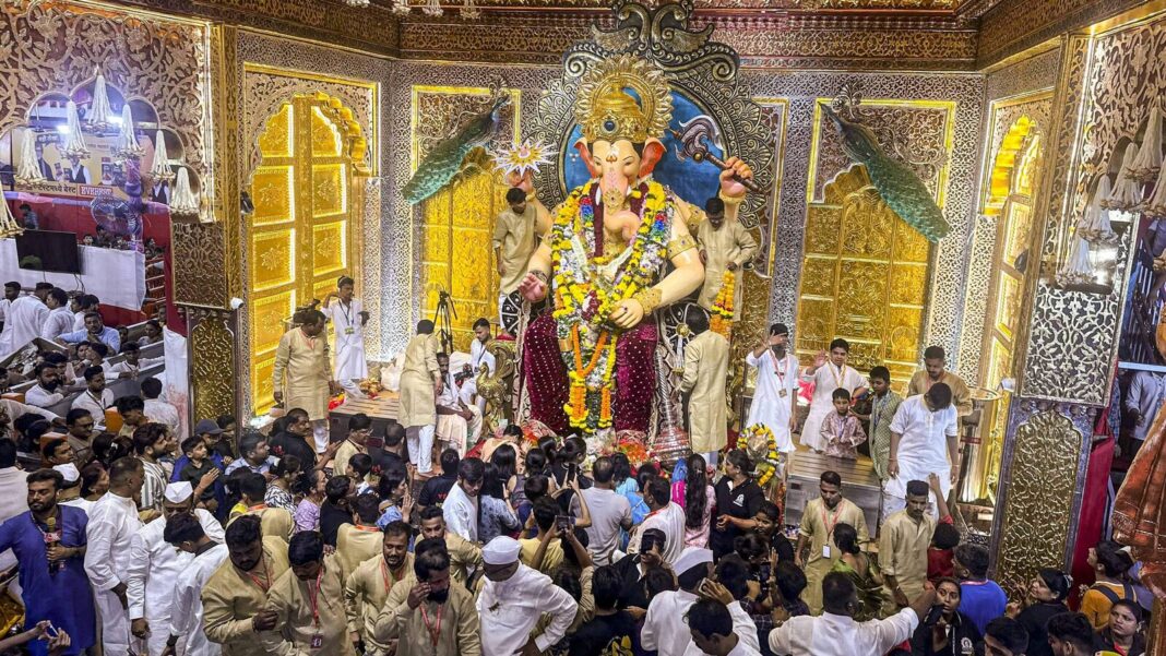 Ganesh idol at crowded Indian festival celebration.