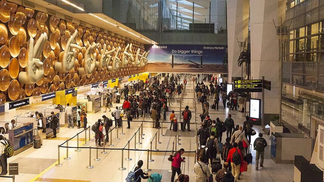 Busy airport terminal with travelers and unique art installation.