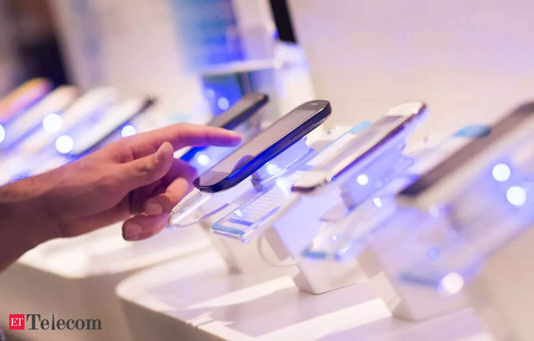 Person examining smartphones on display in store