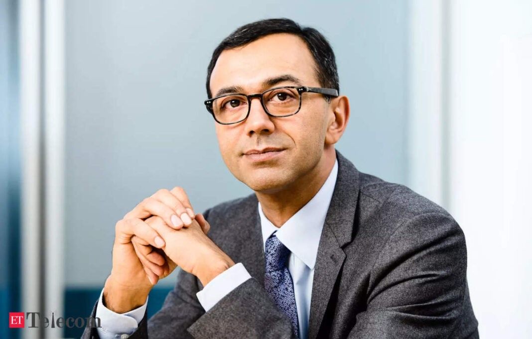 Professional man in suit sitting with clasped hands.