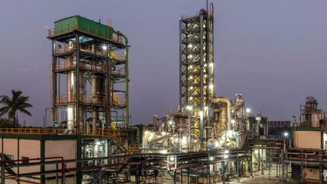 Industrial chemical plant at dusk with lighting.