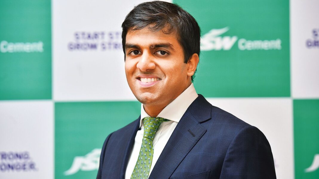 Professional man in suit with green tie smiling.