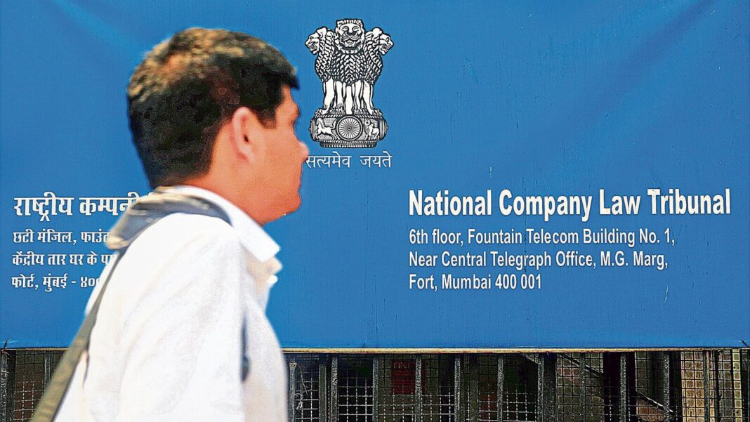 Man walking past National Company Law Tribunal sign.