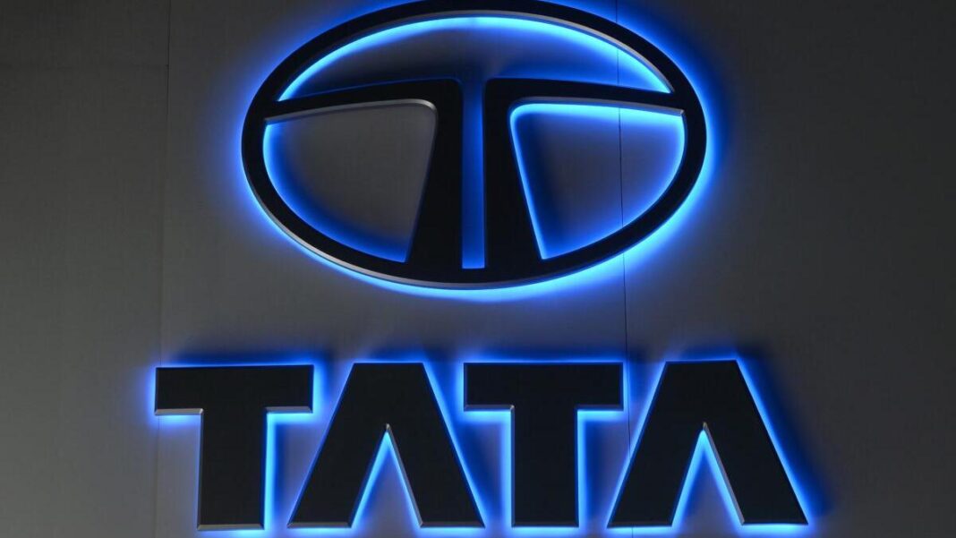 Illuminated TATA company logo sign with blue backlight.